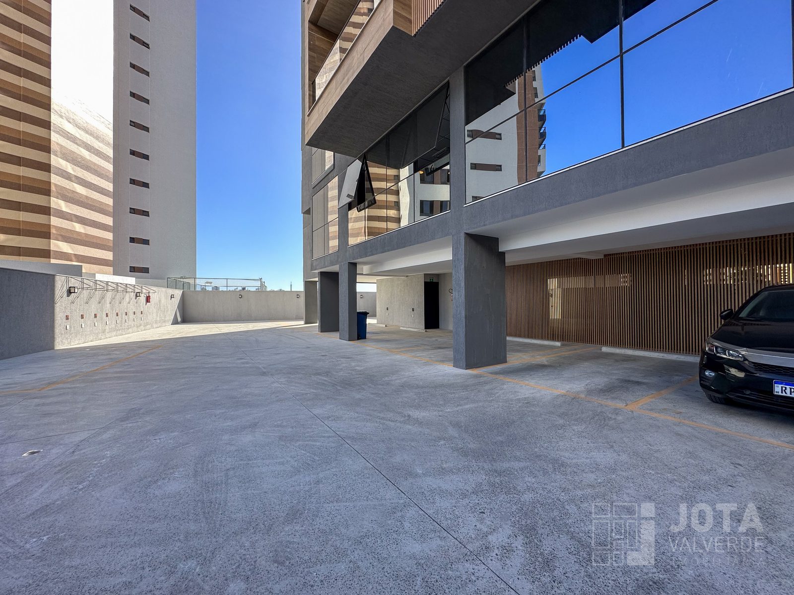 Garagem do edifício, com vagas demarcadas e bicicletário na parede lateral