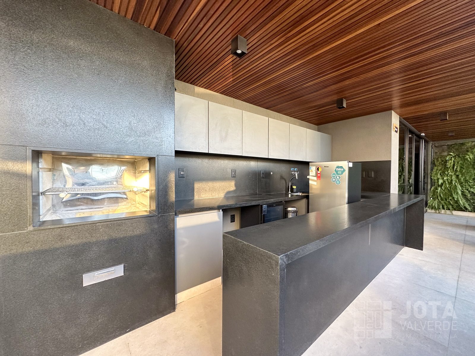 Espaço gourmet com churrasqueira, bancada e adega, no Hype Concept Home