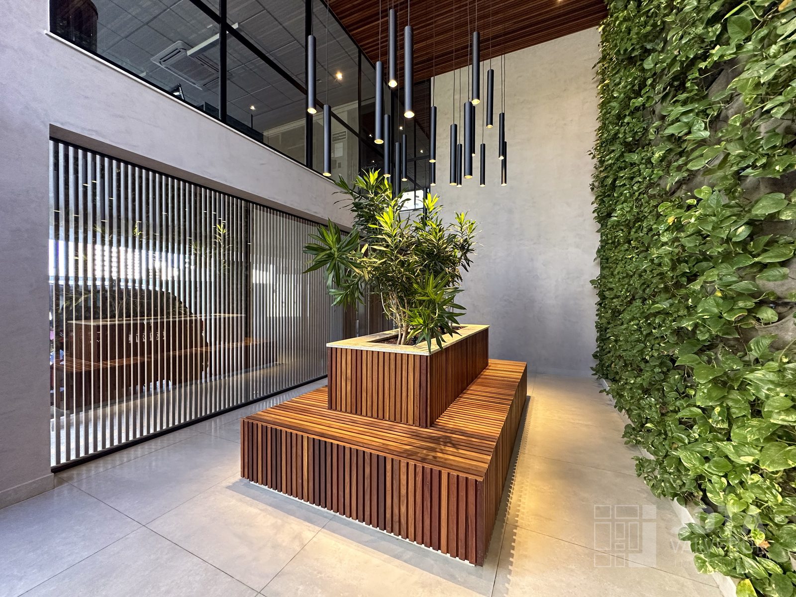 Hall de entrada com pé-direito duplo, jardim vertical e banco de madeira