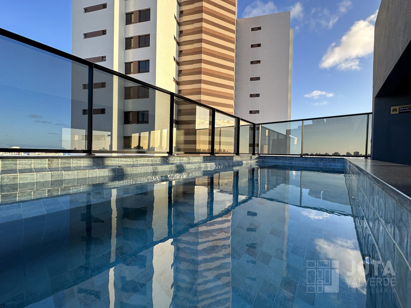 Piscina na cobertura do Hype Concept Home, com guarda-corpo de vidro e vista para Salvador