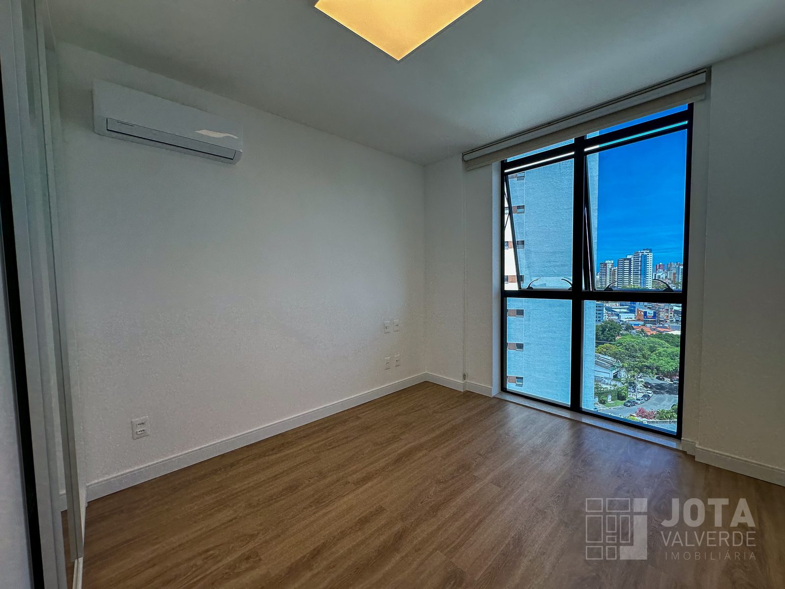 Quarto com janela ampla, ar-condicionado e piso vinílico amadeirado
