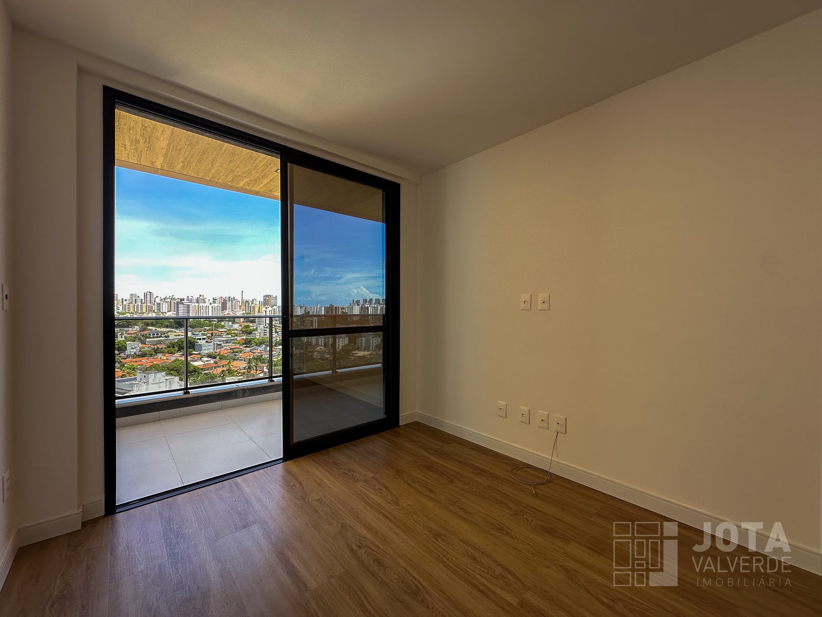 Quarto do apartamento com porta de correr para a varanda