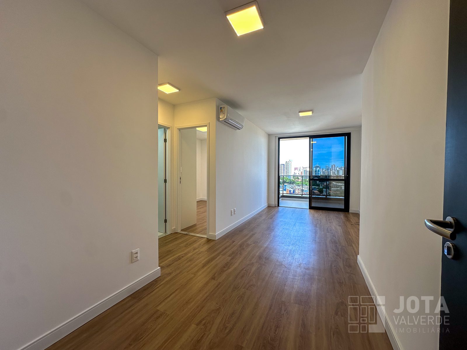 Sala do apartamento à venda no Caminho das Árvores, com piso vinílico e porta de correr para a varanda
