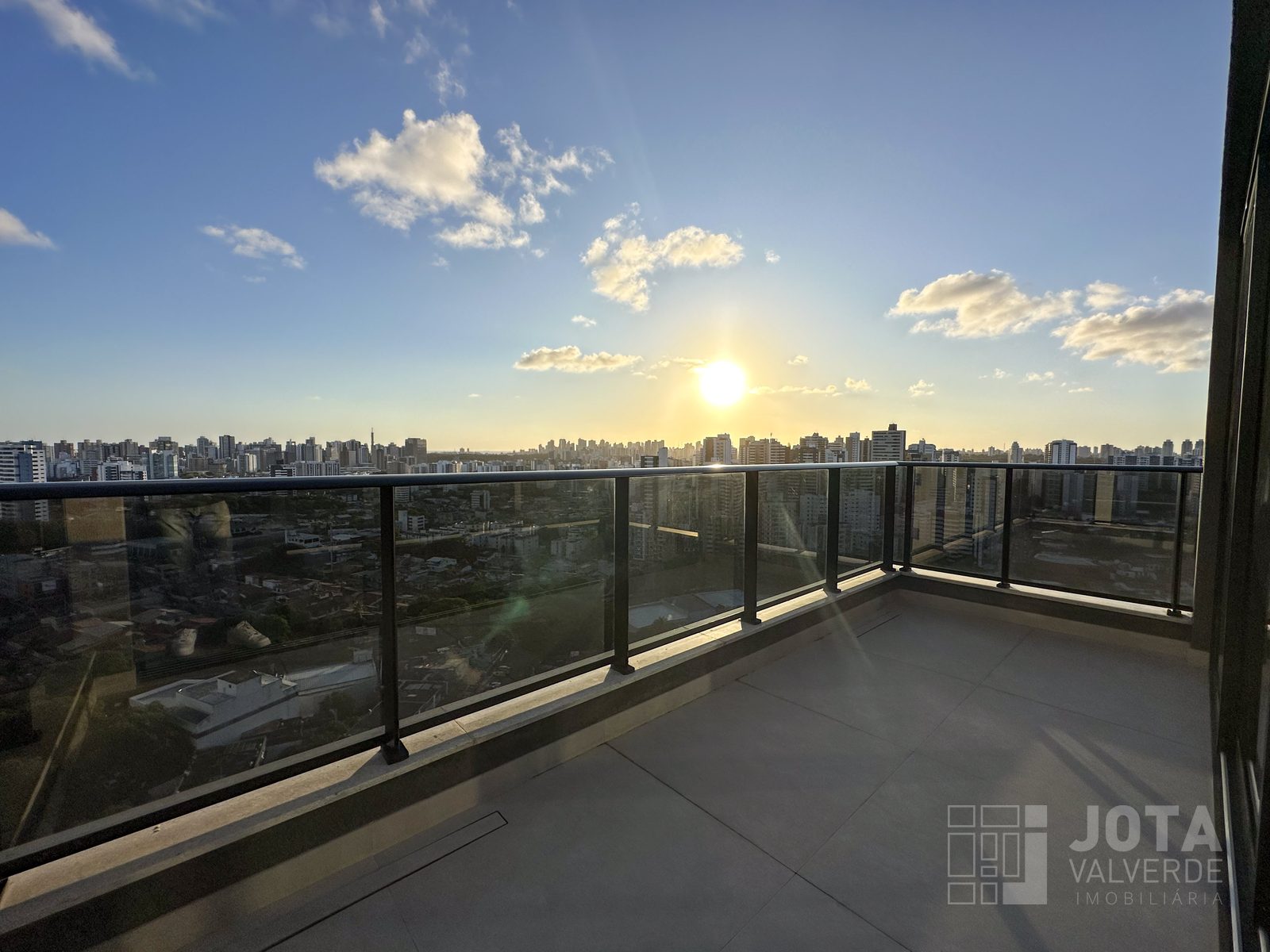 Terraço da cobertura ao pôr do sol, com vista para o skyline de Salvador