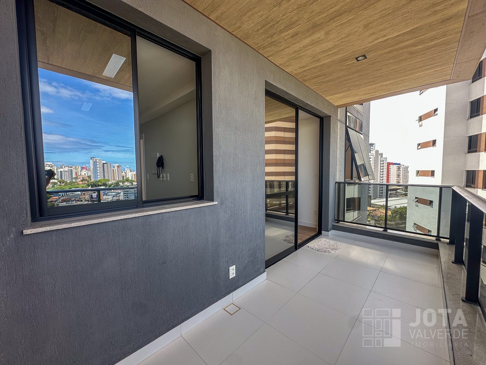 Varanda do apartamento no Hype Concept Home, com forro de madeira e vista para o Caminho das Árvores
